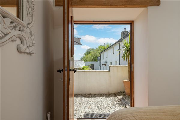 Bedroom door open with view of terrace and farmhouse.